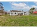 A charming single-story home showing a large yard, detached garage, and a porch with a swing at 5902 Sunset Dr, Indianapolis, IN 46239