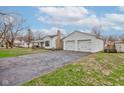 Quaint single-story home with a detached two-car garage and a cracked driveway at 5902 Sunset Dr, Indianapolis, IN 46239