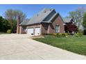 Brick home with a three-car garage and a long driveway at 6010 Fawnwood Dr, Greenwood, IN 46143