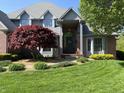 Stunning home with well-maintained lawn and landscaping, featuring an arched front door and bay window at 6010 Fawnwood Dr, Greenwood, IN 46143