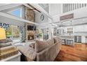 Bright, open-concept living room with a stone fireplace, hardwood floors, and access to outdoor living space at 6517 Chipmunk Ct, Nineveh, IN 46164