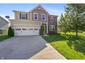 Beautiful exterior of home with a well-maintained lawn, nice tree and a two car garage at 6615 School Branch Dr, Brownsburg, IN 46112