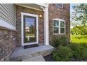 Inviting front entrance features stone accents, a decorative storm door and well-maintained landscaping at 6615 School Branch Dr, Brownsburg, IN 46112