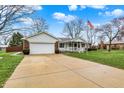 Inviting single-story home with a spacious driveway, green lawn, and charming covered front porch at 6958 W Brier Creek Dr, New Palestine, IN 46163
