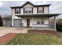Charming two-story home featuring red shutters, a covered porch, and a convenient attached garage at 7130 English Birch Ln, Indianapolis, IN 46268