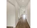 Bright hallway showcasing hardwood floors, white walls, and access to multiple rooms at 7170 Rose Hill Ave, Brownsburg, IN 46112