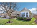 A charming home's exterior is framed by a tree, showcasing its well-maintained lawn and inviting architecture at 7337 Red Maple Dr, Zionsville, IN 46077