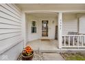 Covered porch area with welcome sign, outdoor seating, potted flowers, and a charming home entrance at 7347 Blue Creek S Dr, Indianapolis, IN 46256