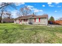 Attractive single-story home boasts a stone exterior, vibrant red shutters, and manicured lawn at 7530 Savannah Dr, Indianapolis, IN 46217