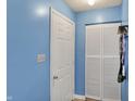 Hallway features blue painted walls, closet with sliding doors, and a white entry door at 7530 Savannah Dr, Indianapolis, IN 46217
