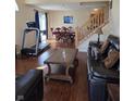 Cozy living room with hardwood floors, leather furniture, and view into the dining area at 8160 Shores Edge Way, Indianapolis, IN 46237
