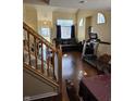 Open concept living area featuring hardwood floors, a stairway, and a comfortable seating area at 8160 Shores Edge Way, Indianapolis, IN 46237