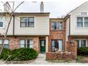 Charming townhome exterior with brick and siding, highlighted by a vibrant green front door at 9449 Maple Way, Indianapolis, IN 46268