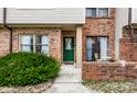 Inviting brick townhome facade with a bright green front door and an enclosed brick patio at 9449 Maple Way, Indianapolis, IN 46268