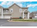 Townhouse exterior featuring neutral siding, a well-manicured lawn, and two-car garage at 1160 Falcon Rdg, Carmel, IN 46280