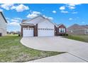 Beautiful exterior view of a home with a wide driveway and lush green grass at 1347 Shaw Ln, Shelbyville, IN 46176