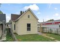 Side view of a cream two-story home featuring new roofing and traditional architectural details at 1426 S Talbott St, Indianapolis, IN 46225