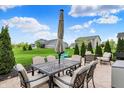 Outdoor dining set with seating for six is featured on the concrete patio and green lawn at 15752 Matthews Ln, Noblesville, IN 46060