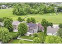 Beautiful aerial view of a private backyard with mature trees, a white fence, and solar panels on the roof at 15898 Bounds Dr, Noblesville, IN 46062