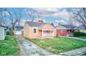 A cozy one-story home featuring a well-maintained lawn and a charming front porch at 1940 N Drexel Ave, Indianapolis, IN 46218