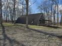 Unique home with a Quonset hut style design, surrounded by trees, providing a rustic charm at 21977 Craig Ave, Noblesville, IN 46060