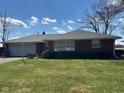 Charming brick home showcasing a well-maintained lawn, concrete driveway, and an attached one-car garage at 2309 Dover St, Anderson, IN 46013
