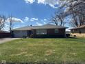 Charming brick home featuring a lush green lawn, concrete driveway, and an attached one-car garage at 2309 Dover St, Anderson, IN 46013