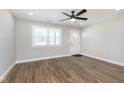 Open-concept living space with hardwood floors, a bright window, and a contemporary ceiling fan at 240 E Caven E St, Indianapolis, IN 46225