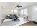 Bright living room featuring neutral walls, contemporary furniture, a modern ceiling fan, and stylish rug at 240 E Caven E St, Indianapolis, IN 46225