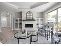 Comfortable living room featuring built-in cabinets, a white brick fireplace, and lots of natural light at 2786 Kipling Dr, Carmel, IN 46033