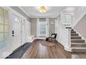 Bright foyer with hardwood floors, a white staircase, and a coat rack with seating at 3345 Ruckle St, Indianapolis, IN 46205