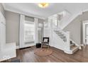 Cozy foyer with hardwood floors, a staircase, and a decorative chair next to a window at 3345 Ruckle St, Indianapolis, IN 46205
