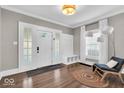 Welcoming foyer featuring hardwood floors, a decorative light fixture, and a coat rack with seating at 3345 Ruckle St, Indianapolis, IN 46205