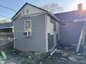 Rear exterior showing siding and an air conditioning unit in the window, presenting an image of the property needing repair at 3422 Hillside Ave, Indianapolis, IN 46218