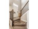 Stylish entryway with wood stairs, modern railing, and a charming woven accent cabinet at 3535 Buckner Dr, Westfield, IN 46074