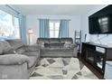Bright living room with ample seating, modern TV, and decorative curtains at 3618 Spann Ave, Indianapolis, IN 46203