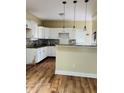 Well-lit kitchen with white cabinets, granite countertops, and modern pendant lighting at 426 Eastern Ave, Indianapolis, IN 46201