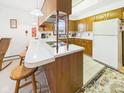 Functional kitchen featuring a breakfast bar, white countertops, and light wood cabinetry at 5449 S 100 W, Anderson, IN 46013