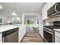 Well-equipped kitchen with stainless steel appliances, modern cabinetry, island, and view to backyard at 620 Corbin Way, Avon, IN 46123