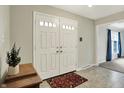 Bright foyer with double front doors, tile flooring, and view into living room at 6537 Grosvenor Pl, Indianapolis, IN 46220