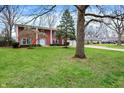 A brick two-story home with manicured lawn and established trees at 6537 Grosvenor Pl, Indianapolis, IN 46220