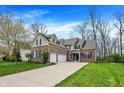Beautiful brick home with a manicured lawn, complemented by a spacious driveway and attached two-car garage at 7562 Black Walnut Dr, Avon, IN 46123
