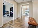 Well-lit hallway showcases hardwood floors and views of an office space and an inviting dining room at 8818 Tributary Dr, Indianapolis, IN 46259