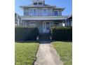 Classic two-story home with a cozy front porch, mature landscaping, and a well-maintained lawn at 925 E Main St, Muncie, IN 47305