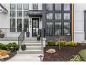 Inviting front entrance with landscaped flower beds leading to a modern door and gray exterior accents at 11003 Holliday Farms Blvd, Zionsville, IN 46077