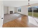 Bright living room featuring a fireplace, large windows, and hardwood flooring transitioning to carpet at 11063 Deer Valley Dr, Indianapolis, IN 46229