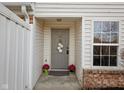 Inviting front door with a wreath, potted flowers, and a doormat at 11475 Clay Ct # 102, Fishers, IN 46037