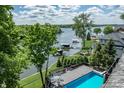 Breathtaking aerial view of waterfront home with a backyard pool and a private dock on a serene lake at 11941 Sand Dollar Cir, Indianapolis, IN 46256