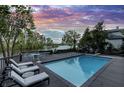 Relaxing backyard with a sparkling pool, poolside lounge chairs, and scenic views of the adjacent lake at 11941 Sand Dollar Cir, Indianapolis, IN 46256
