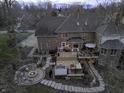 Aerial view of a brick home's backyard featuring a hot tub and outdoor seating area with a fire pit at 12065 Watermark Ct, Indianapolis, IN 46236